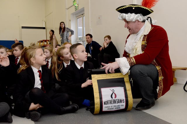 Northern Saints School pupils listening to teacher and acting town crier Chris Tarpey in 2020.