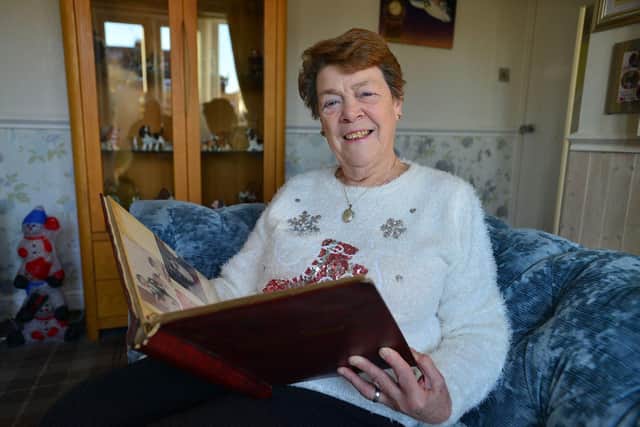 June Gowland looks at old photos of some of the children she fostered. Picture by FRANK REID