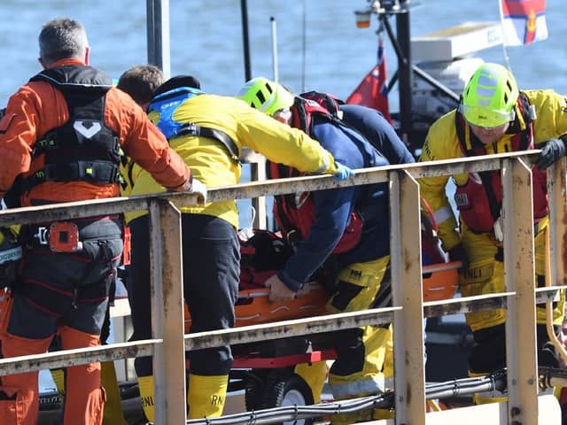 The injured fisherman is stretchered from the all weather lifeboat to an ambulance at the lifeboat station. (Photo: RNLI/Tom Collins)