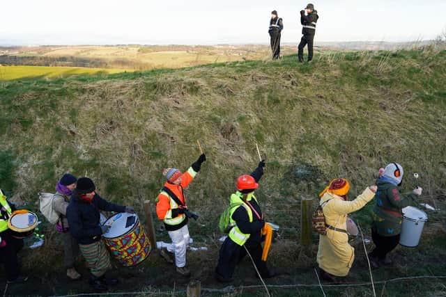 Security guards watch as Extinction Rebellion demonstrators walk along the perimeter fence as they begin their second of a three-day mass action protest at the Bradley Open Cast coal mine. Photo by Ian Forsyth/Getty Images.