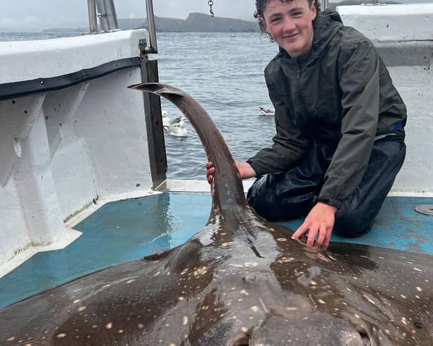 Edward Davies, 15, catches a large common skate whilst on a fishing expedition in Scotland.