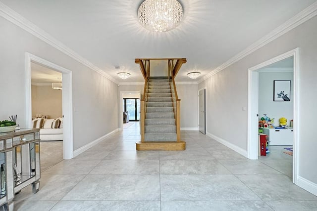 This large entrance hall is grand in style and features an oak staircase.