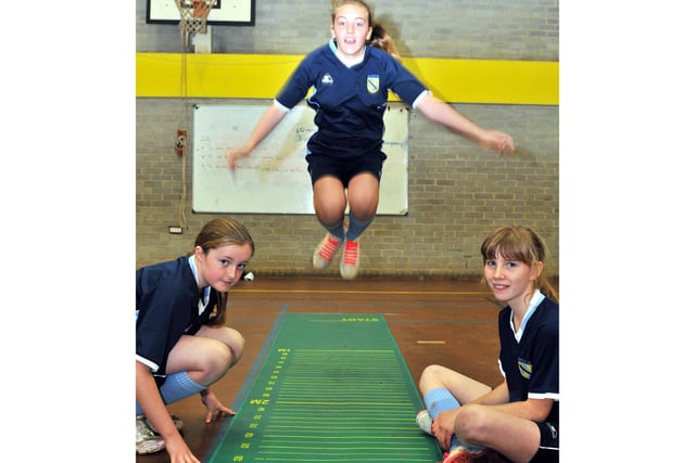 Pupil Shelby Swinbourne pictured jumping in 2011 as fellow pupils Hannah Doble (left) and Neve Galloway wait to measure her distance.