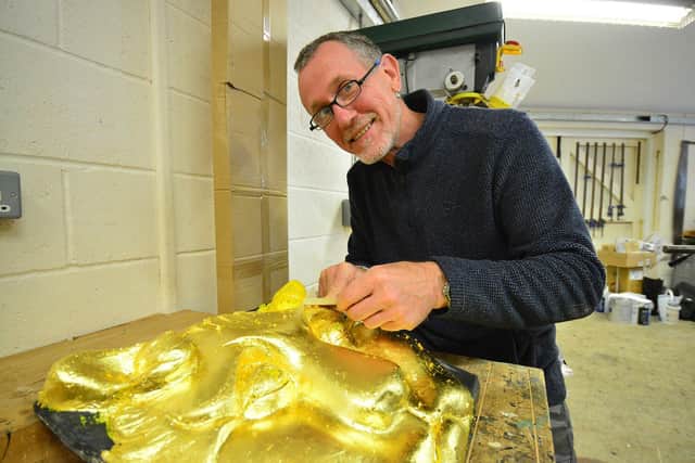 Gilder Nigel Searle applying gold leaf paint.