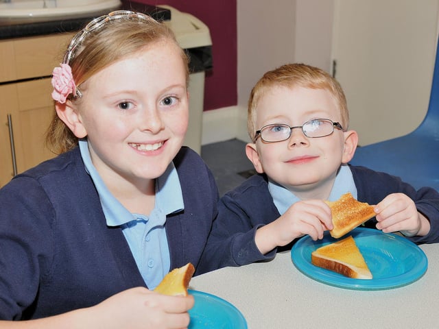 Nicole Gray (11) and Curtis Morfoot (5) enjoying their toast at the breakfast club at Owton Manor Primary School in 2013.