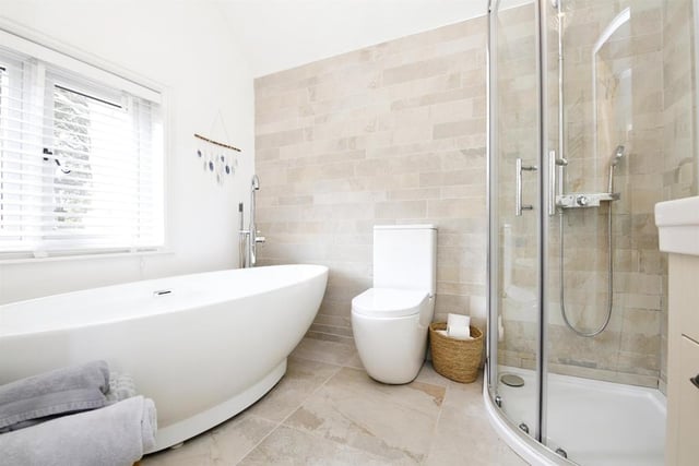 The master bedroom en-suite features a free standing bath and a shower cubicle with rain shower.