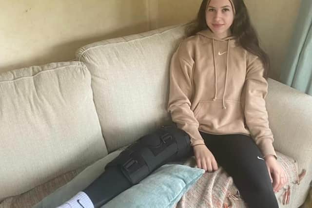 Izzy Harnett-Wood, 15, with her knee in a leg brace waiting for an MRI appointment.