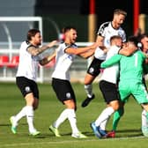 Gateshead players celebrate with their goalkeeper Bradley James after he saves the last penalty in a penalty shootout to win the Vanarama National League North Play-Off match between Brackley Town and Gateshead.