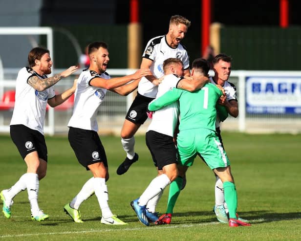 Gateshead players celebrate with their goalkeeper Bradley James after he saves the last penalty in a penalty shootout to win the Vanarama National League North Play-Off match between Brackley Town and Gateshead.
