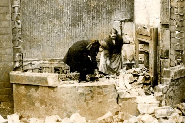 A woman and child attempt to rescue anything they can from the wreckage of their home. Photo: Hartlepool Museum Service.