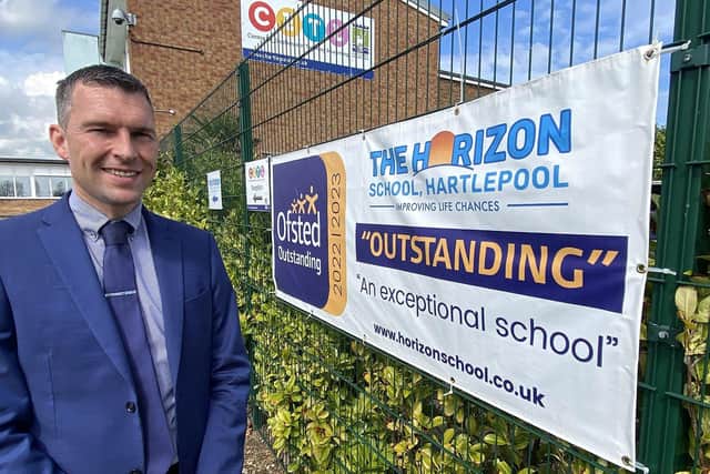 The Horizon School headteacher Martyn Gordon by a banner advertising their Outstanding Ofsted inspection report. Picture by FRANK REID