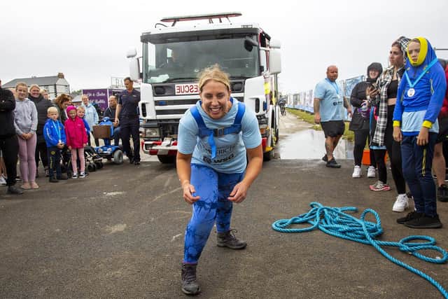 Joanne Spence pulls the fire engine at the Miles for Men event.