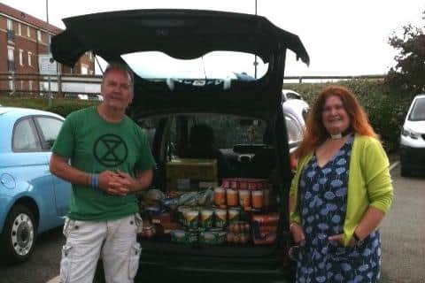 Reverend Roz Hall and her husband with their car full of much needed supplies for the church food bank.