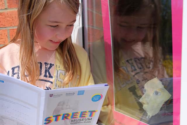A girl finds an exhibit in a window in Blackhall for the Street Museum exhibition. Picture by Alan Sill.