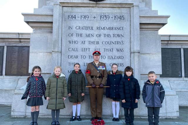Pupils Taylor, Mila, Polly, Harper, Robert and Ben lay a wreath with Major Robert Mclauchlan and Jane Mclauchlan, Fens Primary School admin assistant.