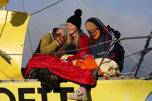 Extinction Rebellion demonstrators and local campaigners sit on a small sailboat reading "Planet Before Profit at the Bradley Open Cast coal mine. Photo by Ian Forsyth/Getty Images