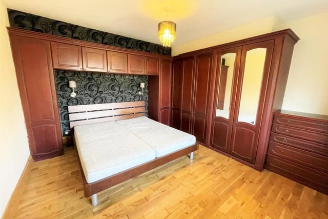 The bedroom boasts fitted wooden wardrobes.
