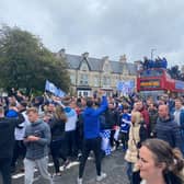 Fans cheer on as the bus passes through the town.
