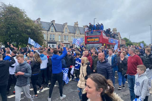 Fans cheer on as the bus passes through the town.