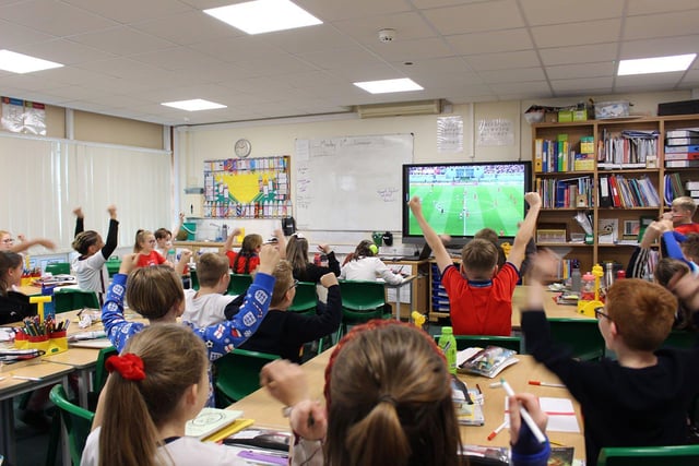 England fans at Fens Primary School celebrate a goal.