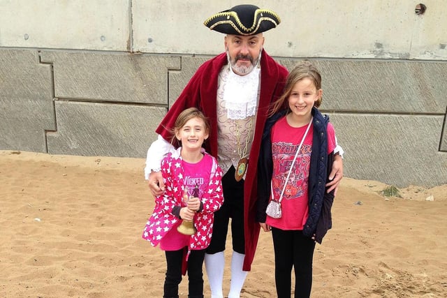 Sophie (left) and Grace Measor were the winners of the Victorian Festival sandcastle competition. Here they are with Town Crier Michael Altringham in 2015.