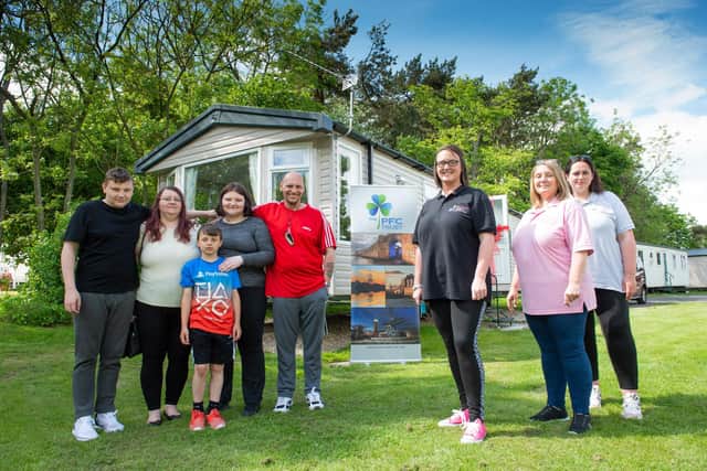 Christine Fewster, pictured third from the right, outside the respite caravan in Northumberland, alongside the Cooper family.