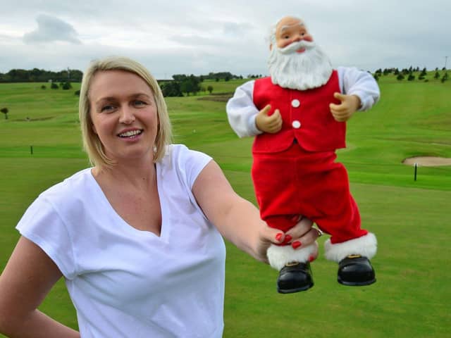 Kelly Barnecutt holds a Santa Clause statue as she sets up the club shop at High Throston Golf Club for their Christmas market in 2021.