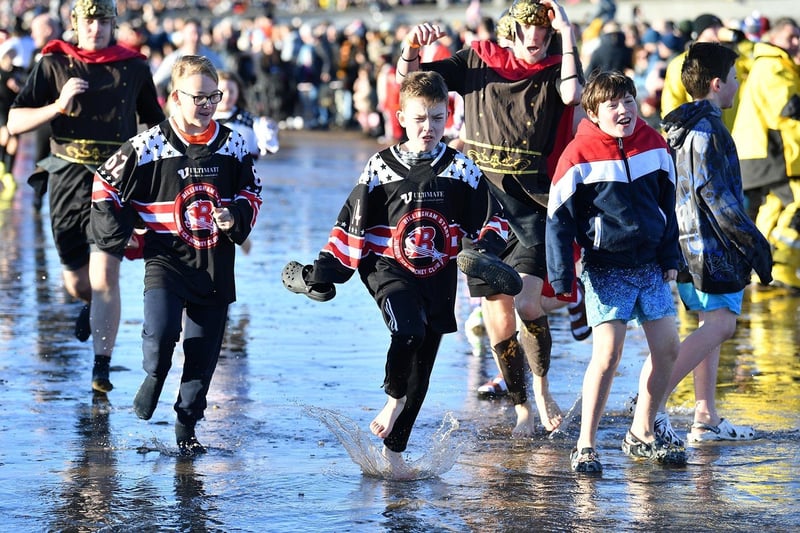 Youngsters from Bilingham Stars Junior Ice Hockey Club head into the surf. Picture by FRANK REID