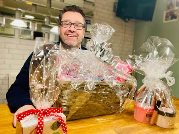 Nicola Kenny Bonus Ball organiser Glen Hughes with some of the prize hampers donated by local firms.