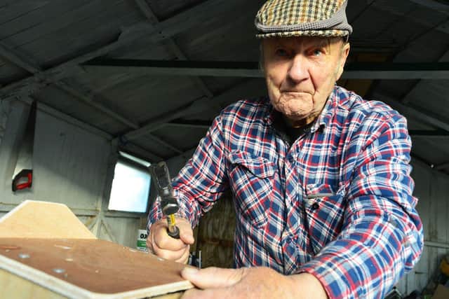 Bob Collin attaching a roof to a bird box he has built./ Photo: Frank Reid