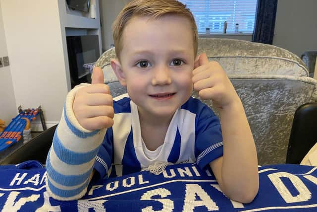 Hartlepool United fan Ollie Kinnersley gives a thumbs up while sporting his blue and white cast on his broken wrist./Photo: Frank Reid