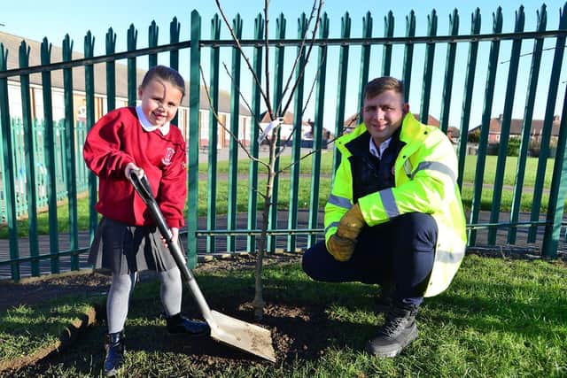 West View Primary school pupil and Eco Warrior team member Poppy Rowbotham plants the apple tree with a helping hand from David Kristopaotis from Fundraise and Recycle./Photo: Frank Reid