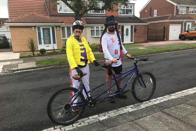 Phil Holbrook and Darrel Slater with their tandem bike dressed as Freddie Mercury and Boy George.
