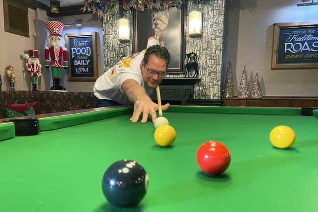 Sean Drinkel shows off the pub's new pool table.