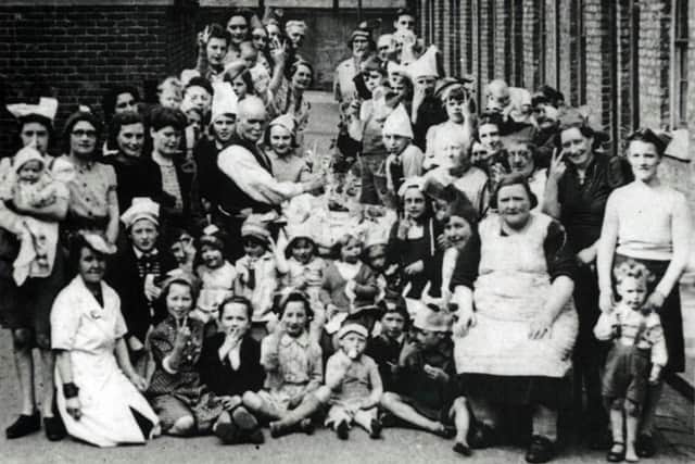 A street party in Mozart Street on VE Day with a number of the party goers displaying the V for Victory sign. Copyright: Hartlepool Borough Council.