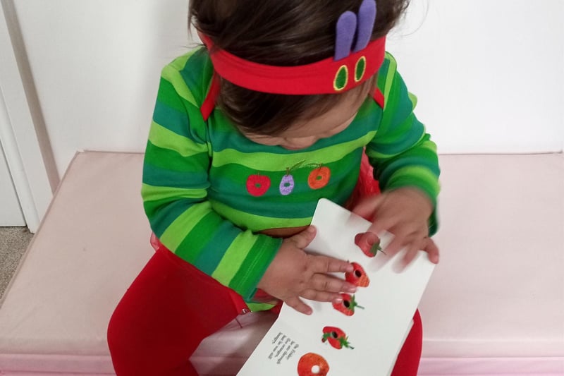 One-year-old Alessia enoying her favourite book 'The Very Hungry Caterpillar"