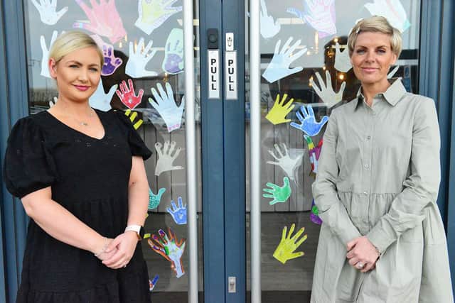 Michaela Porritt (left) and Kirsty Wearmouth (owner) with some of the hand print notes in the door of At Ladies Room. Picture by FRANK REID