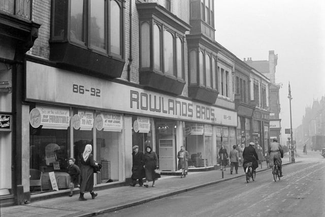 Rowland's furniture store later became the Dovecote Salerooms and the shops further along were Lormor's newsagents and Grafton's. Part of the Empire Theatre can be seen at the far right of the picture.