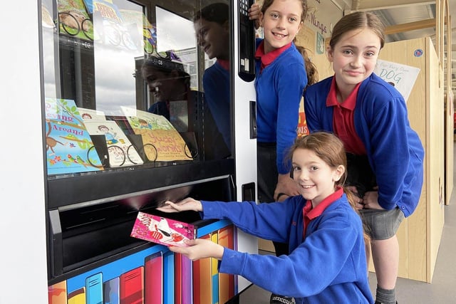 Eloise Grimston, Isabelle Hicks and Marie Gofton cash in their book tokens at the school's book machine in 2022.