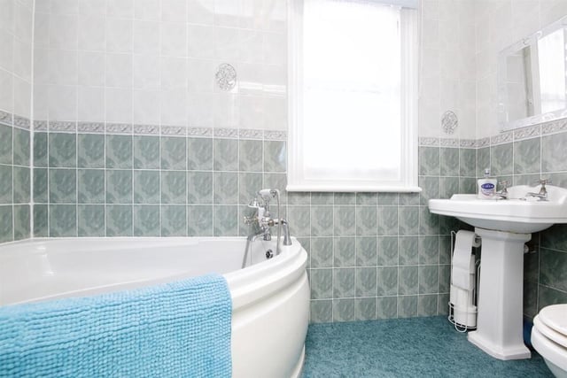 The bathroom is fitted with a large corner bath.