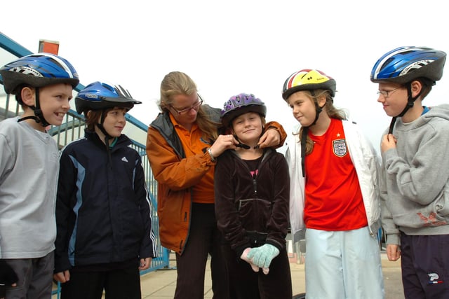 Cycling training instructor Sian McArthur clips up the hat of St John Vianney Primary School pupil Chloe Howgarth as other students look on in 2008.