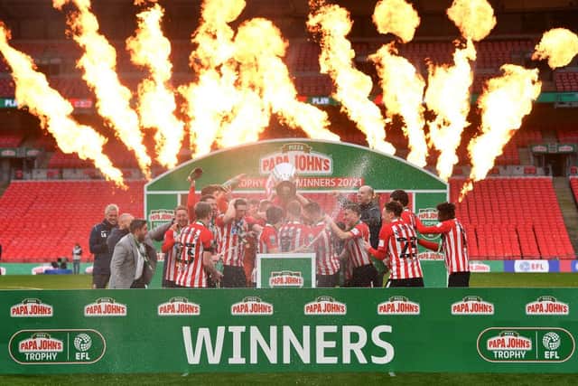 Players of Sunderland celebrate with the Papa John's Trophy after the Papa John's Trophy Final match between Sunderland and Tranmere Rovers on March 14, 2021 in London, England. Sporting stadiums around England remain under strict restrictions due to the Coronavirus Pandemic as Government social distancing laws prohibit fans inside venues resulting in games being played behind closed doors (Photo by Justin Setterfield/Getty Images)