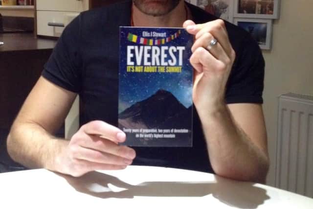 Ellis Stewart with a copy of his book in 2016.