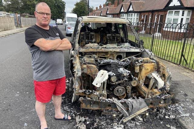 Paul Brackstone alongside the burnt out remains of his Range Rover in Brinkburn Road, Hartlepool. Picture by FRANK REID