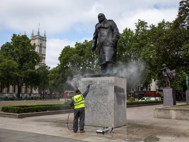A worker cleans the Churchill statue in Parliament Square that had been spray-painted with the words 'was a racist' on June 08, 2020 in London, England. (Photo by Dan Kitwood/Getty Images)