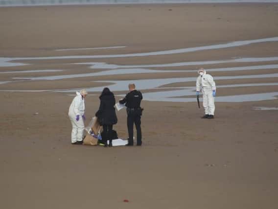 Police officers at the scene of Saturday's discovery of a gun on the beach near Steetley Pier.
