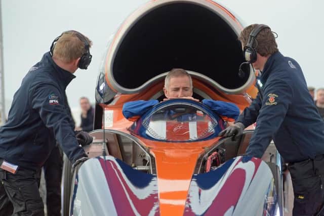 Pilot Andy Green gets into the cockpit of the Bloodhound 1,000mph supersonic racing car before its first public run at Cornwall Airport. Pic: PA.
