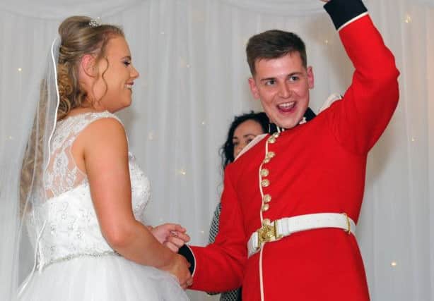 Coldstream Guardsman Josh Obeirne gives a celebratory wave and smile to his fellow Guardsmen after his wedding to Danielle Harrison. Photo by Frank Reid.