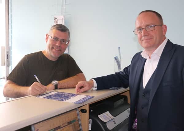 Barry Brown completes the paper work with Chief Executive Mark Maguire as he becomes Hartlepool United's 2,000 season ticket buyer.