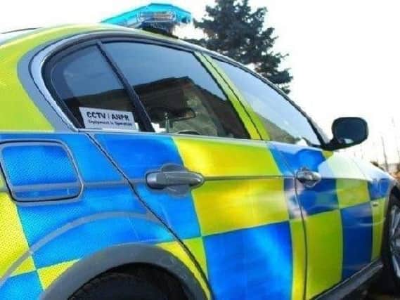 Police have been called to deal with an incident involving a man on a garage roof.